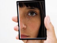 face in a handheld mirror