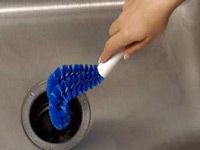 A blue garbage disposal cleaning brush
