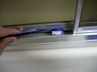 using a toothbrush inside the door runners