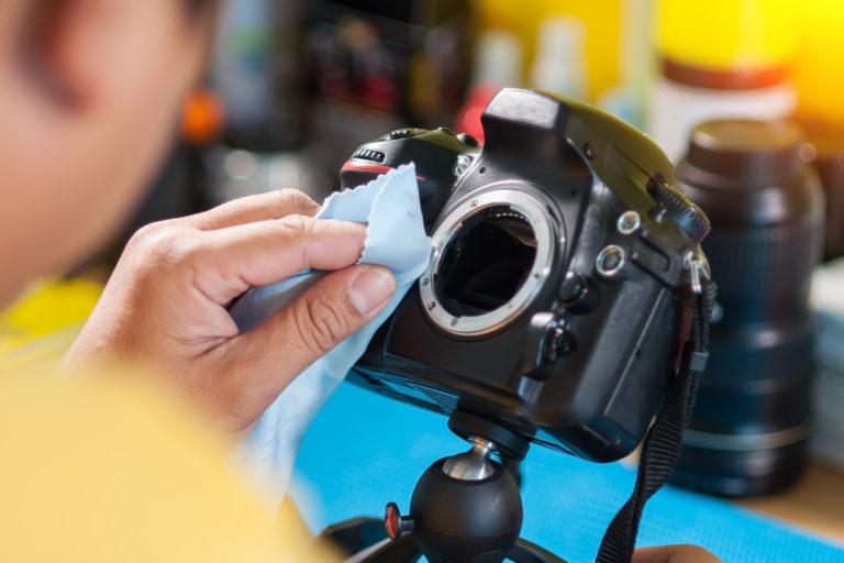 A person cleaning a camera.