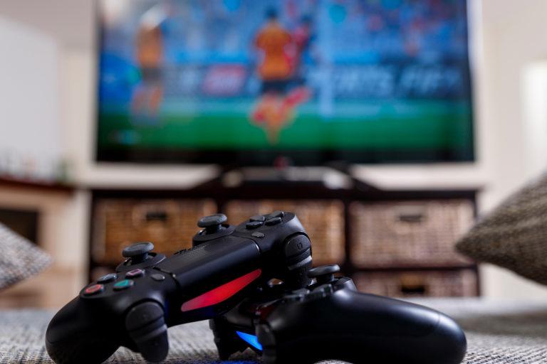 Video game controllers resting on carpet in front of a tv.