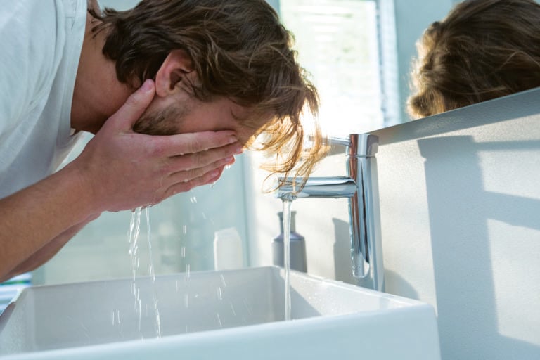 A man washing his face.